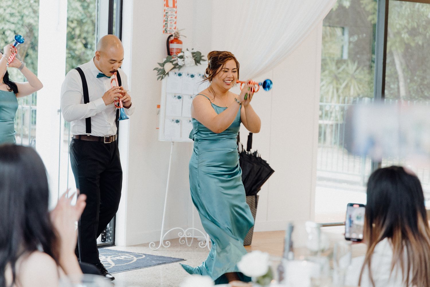 Wedding guests dancing and celebrating with party noisemakers captured by Apertured Media Auckland Wedding Photographer.