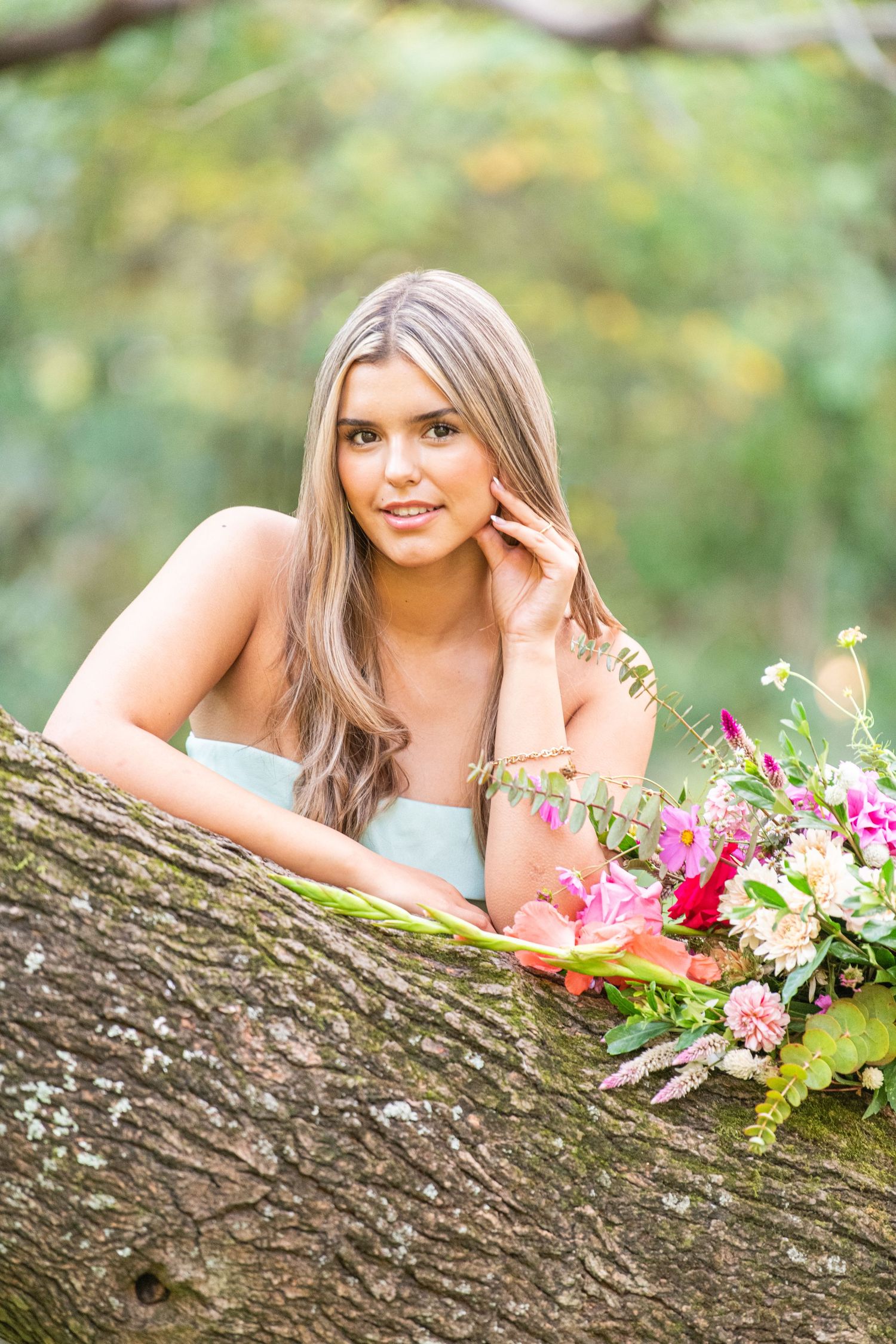 Quinceañera gracefully posing with a bouquet of flowers, radiating elegance and joy on her unforgettable day.