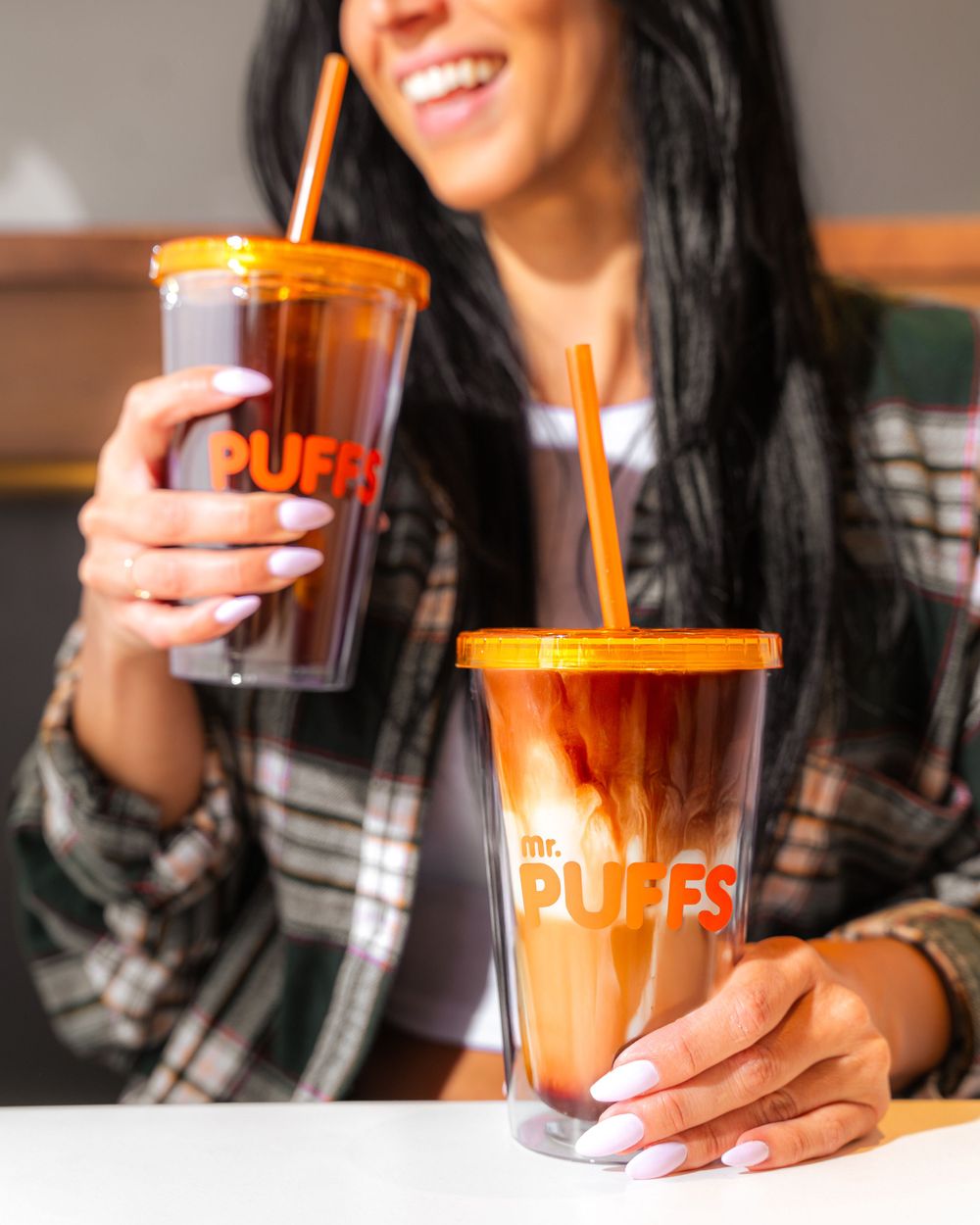Two branded iced drinks displayed on white table surface.Mtlshutter photography