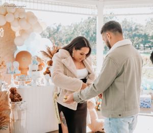Candid moment at a baby shower celebration with neutral-toned decorations.