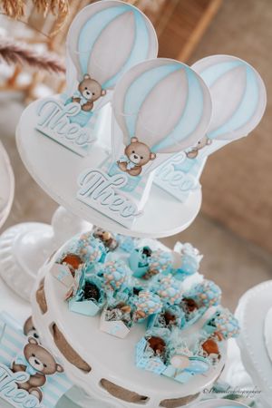 Baby shower dessert display with hot air balloon decorations and blue-themed treats.