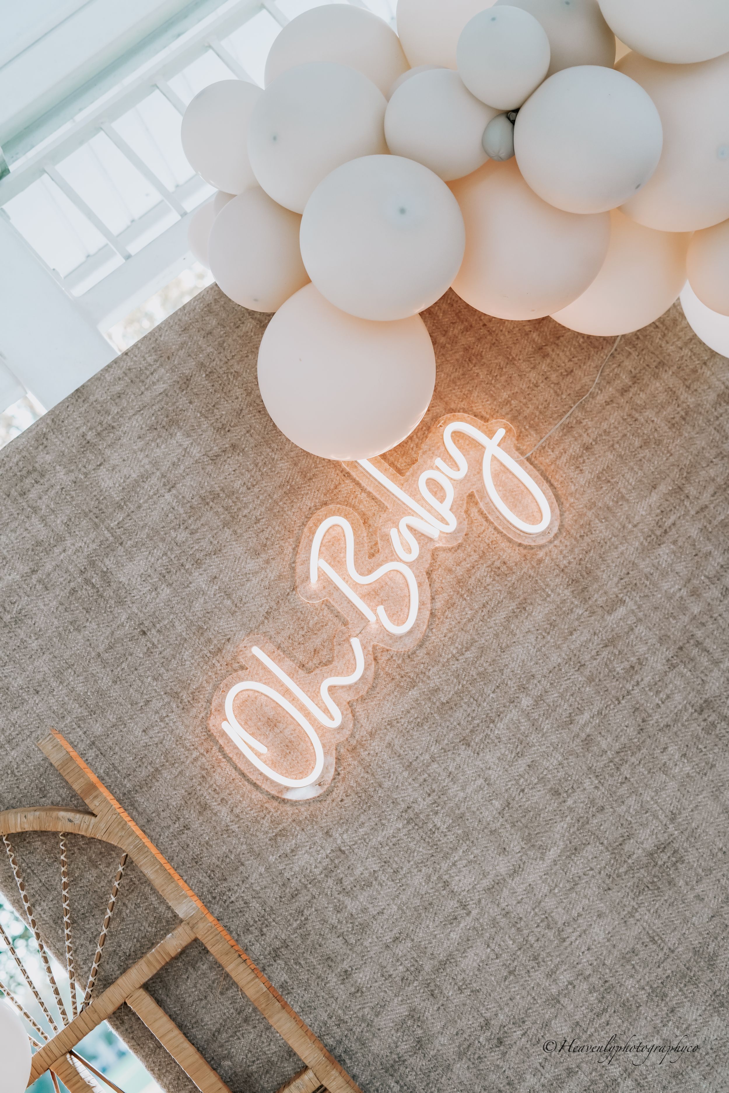 White balloons and neon sign decor against a gray linen backdrop.