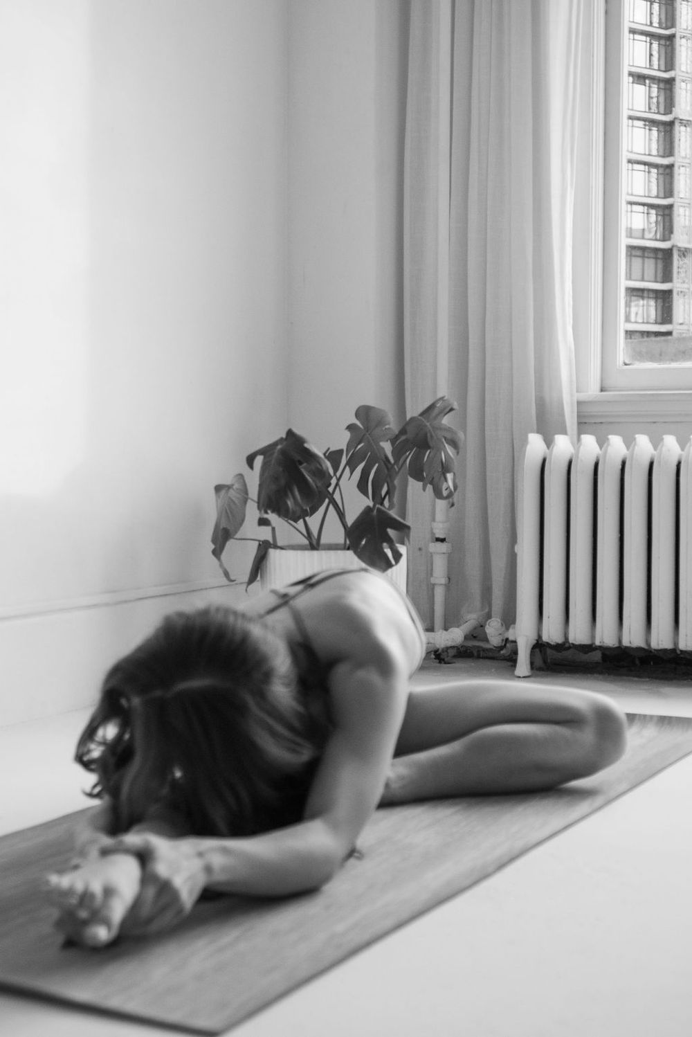 A yoga flow sequence showing various positions on a mat next to a window with soft natural light.