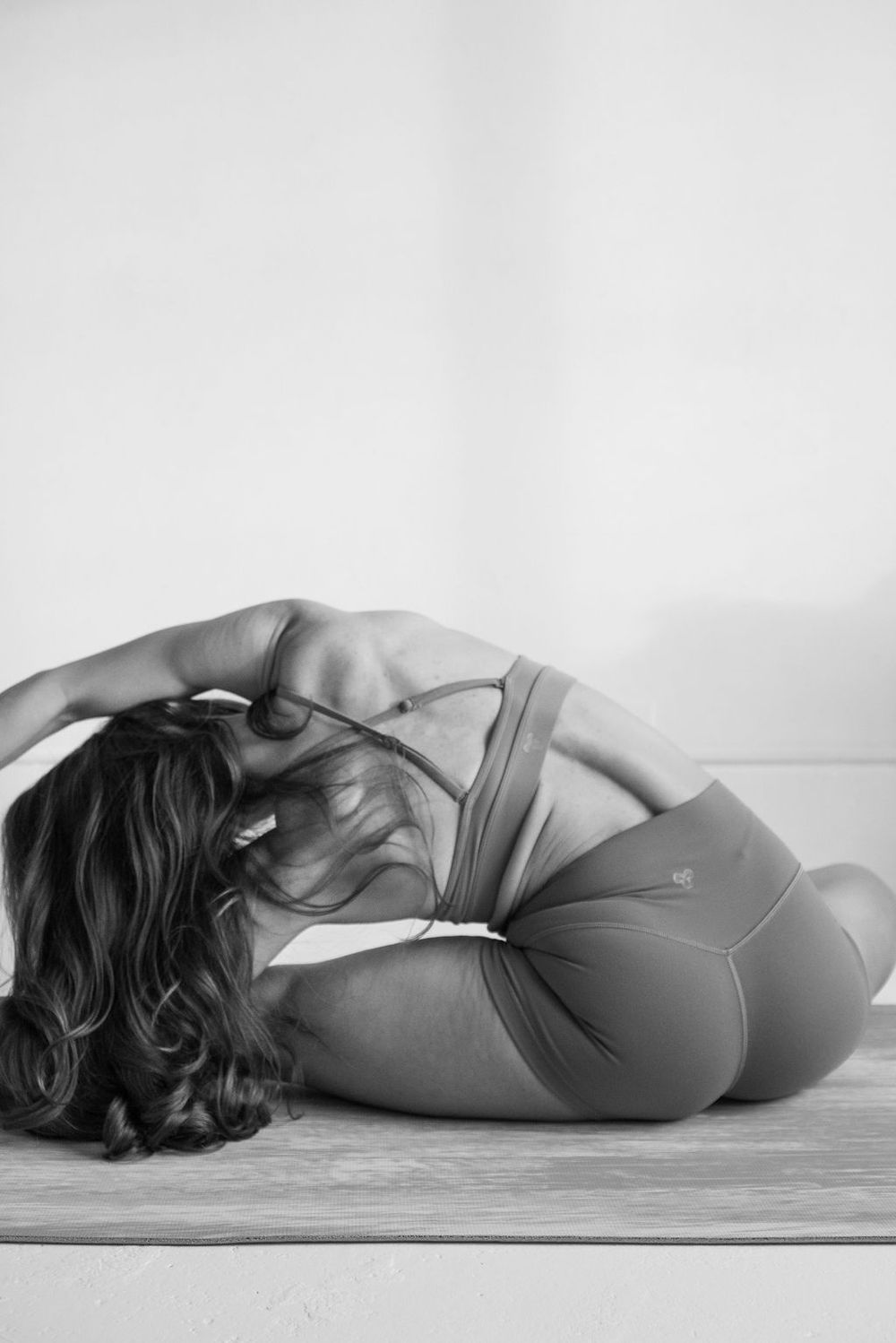 Artistic black and white photographs showing graceful yoga poses against a white background.