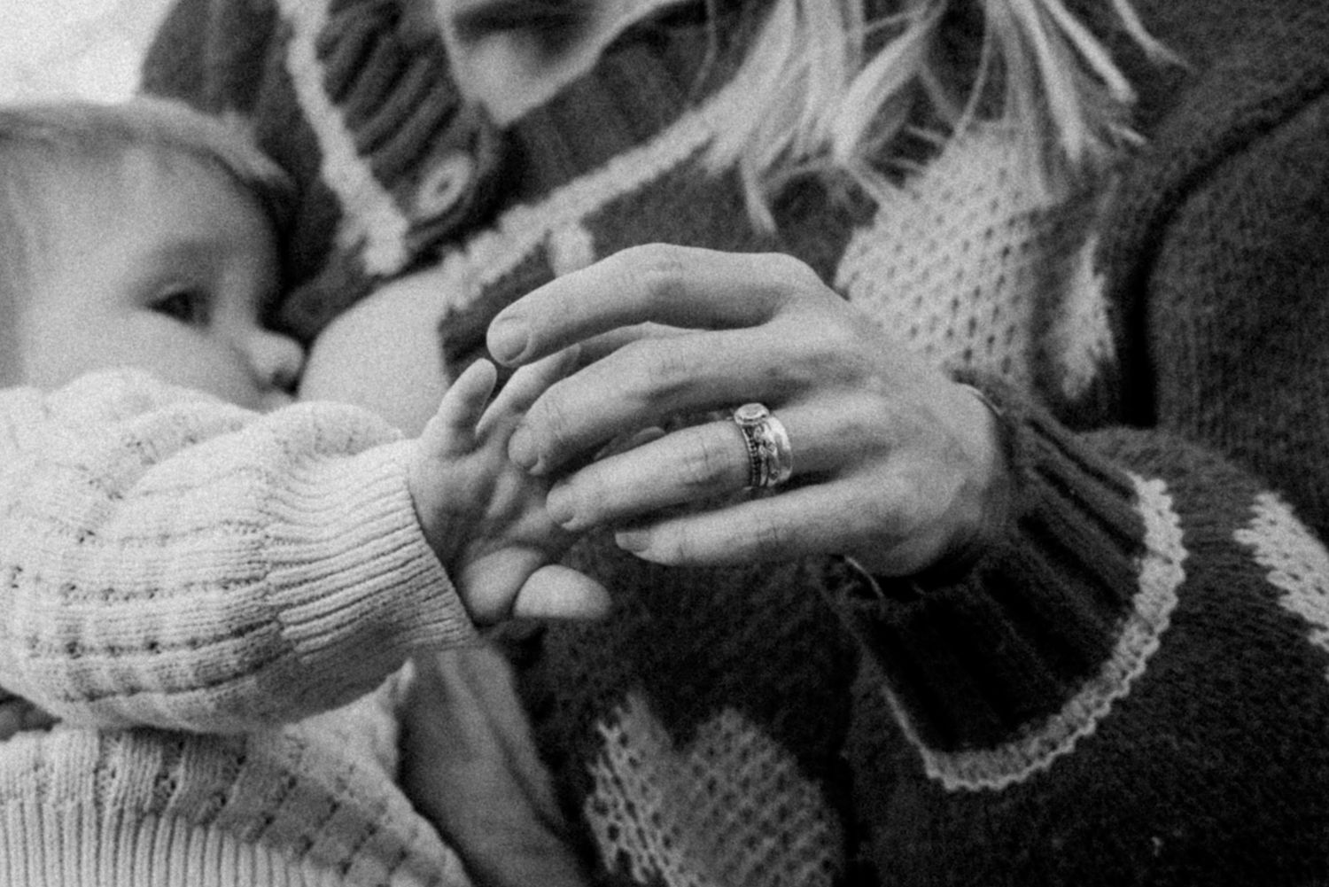 Mother touching their child's hand