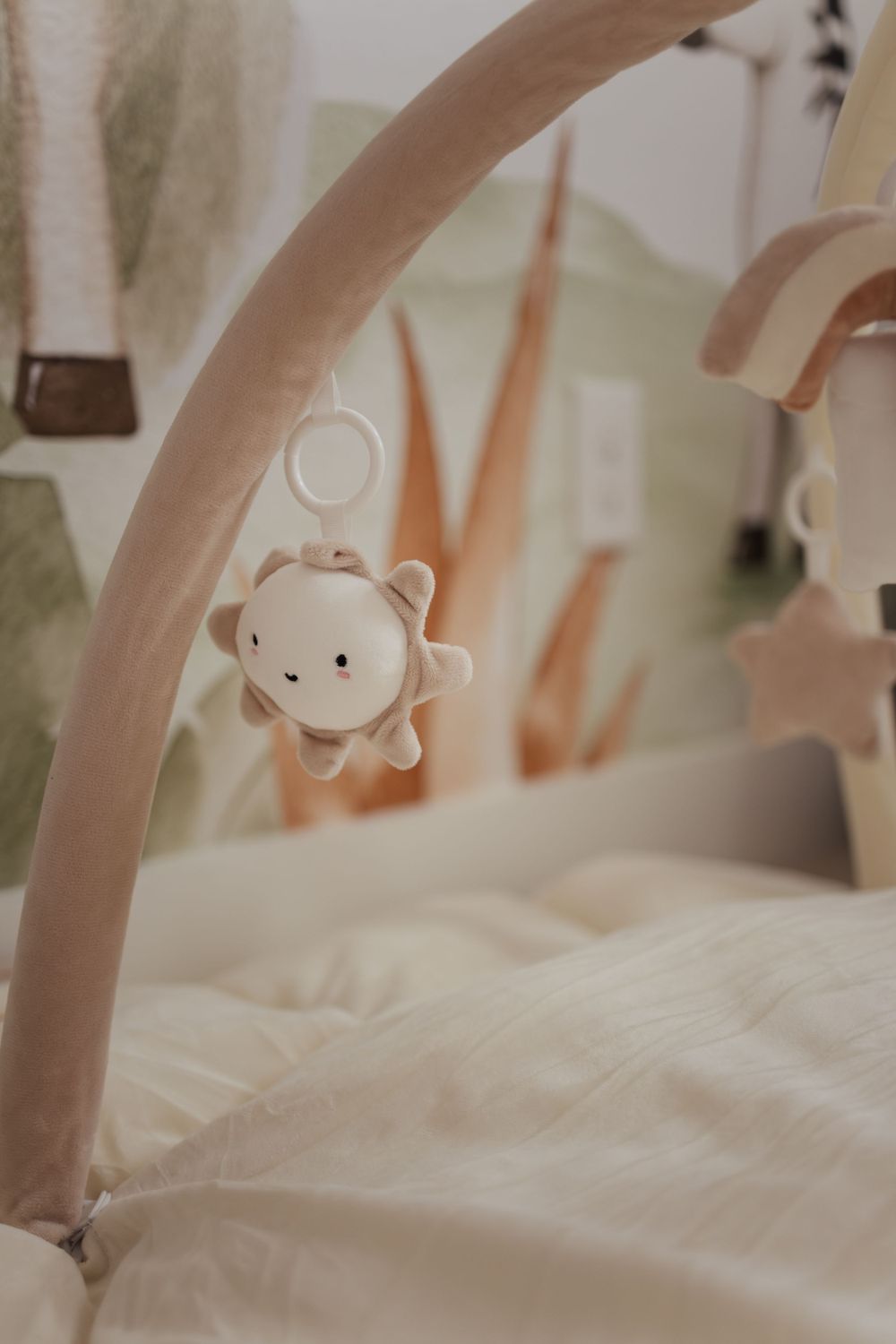 Close-up of a delicate baby mobile with a small white plush toy hanging against a soft, blurred background.