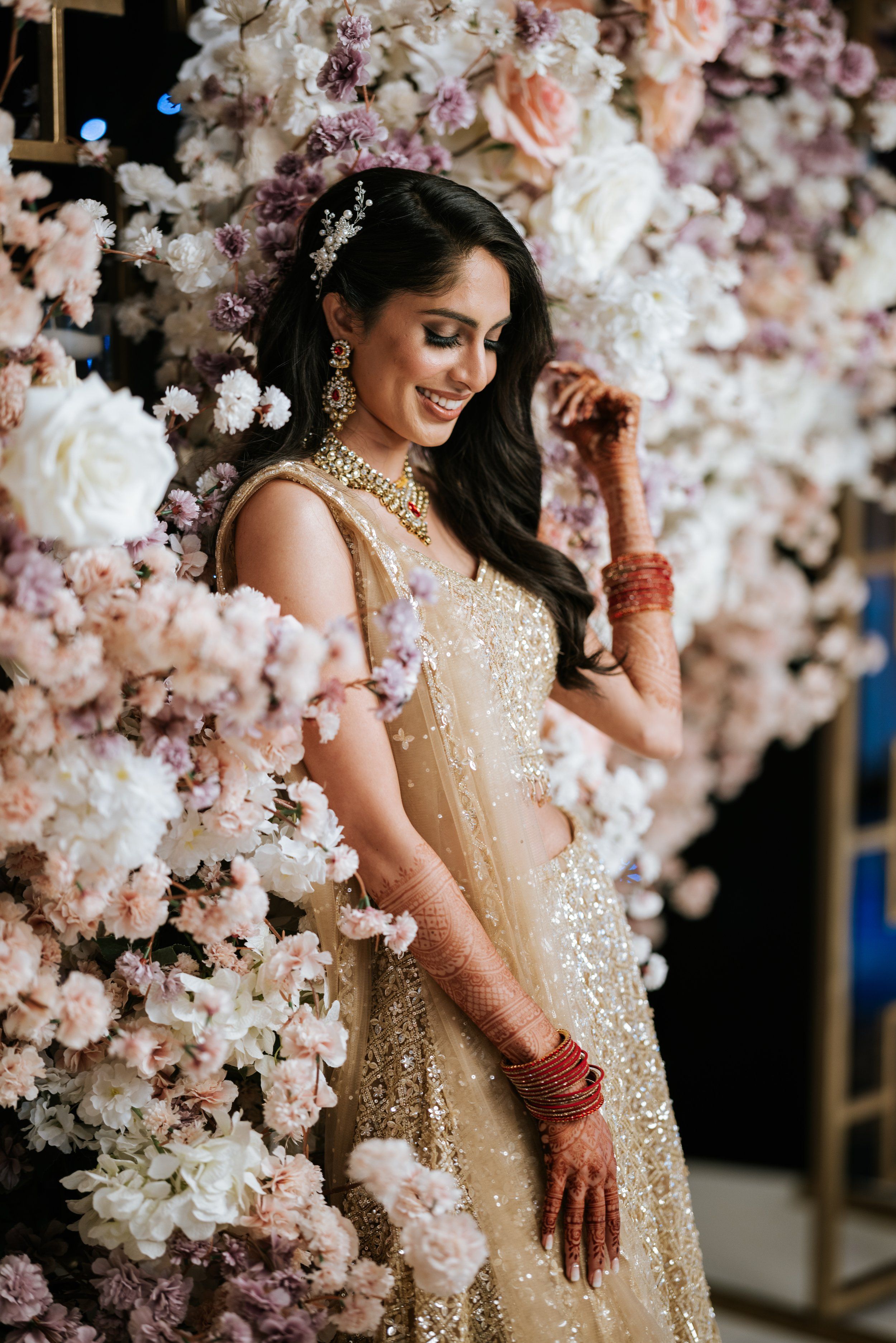 South Asian bride posing among cherry blossoms at The Imperia in Franklin, NJ—perfect blend of elegance and floral beauty.