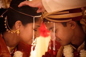 Sacred South Asian wedding moment with bride and groom touching foreheads in a Hindu ceremony, rich in tradition and emotion.