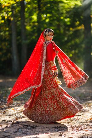 Vibrant Sikh bride twirls in red lehenga at Fairview Park in Falls Church Marriott – colorful Indian wedding photography magic!