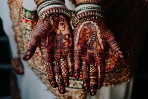Intricate bridal mehndi design at Sheraton Mahwah Hotel for a South Asian wedding, featuring portraits on the palms.