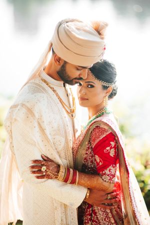 Romantic South Asian wedding portrait at Chase Center on the Waterfront, bride and groom share intimate moment in golden natural light.