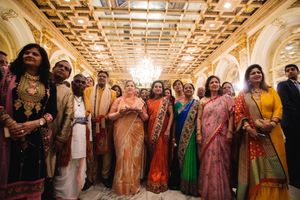 South Asian wedding celebration at Fairmont Copley Plaza with family in vibrant attire under a stunning golden ceiling.