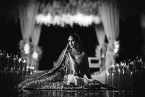 Elegant South Asian bride seated in candlelit aisle at The Marigold in Somerset, NJ — timeless wedding photography in black and white.