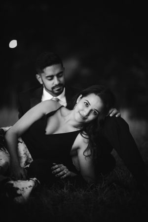 Romantic black and white engagement photo of South Asian couple under moonlight, capturing timeless love and elegance.