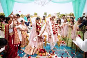 South Asian wedding at Hard Rock Punta Cana, couple exchanges garlands under a tropical mandap surrounded by joyful family and friends.