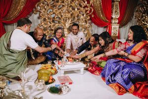 Family gathered for a vibrant South Indian wedding ceremony, performing sacred rituals with colorful decor and joyful expressions.
