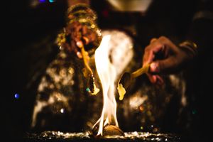 Sacred fire ceremony during a South Asian wedding at Hyatt Regency Reston, with bride and groom performing rituals in glowing candlelight.