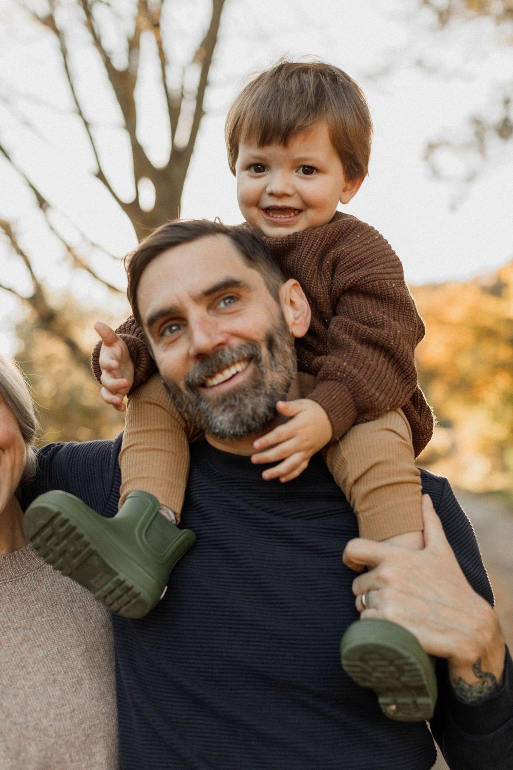 A heartwarming shoulder ride moment during an autumn family photo session.