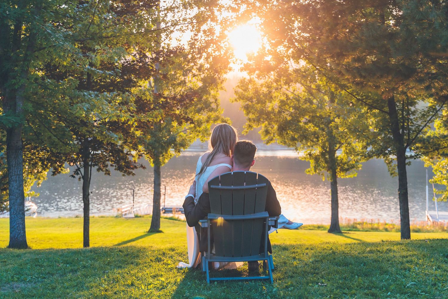 The bride and groom walk together along a picturesque path, illuminated by the beautiful colors of the sunset.