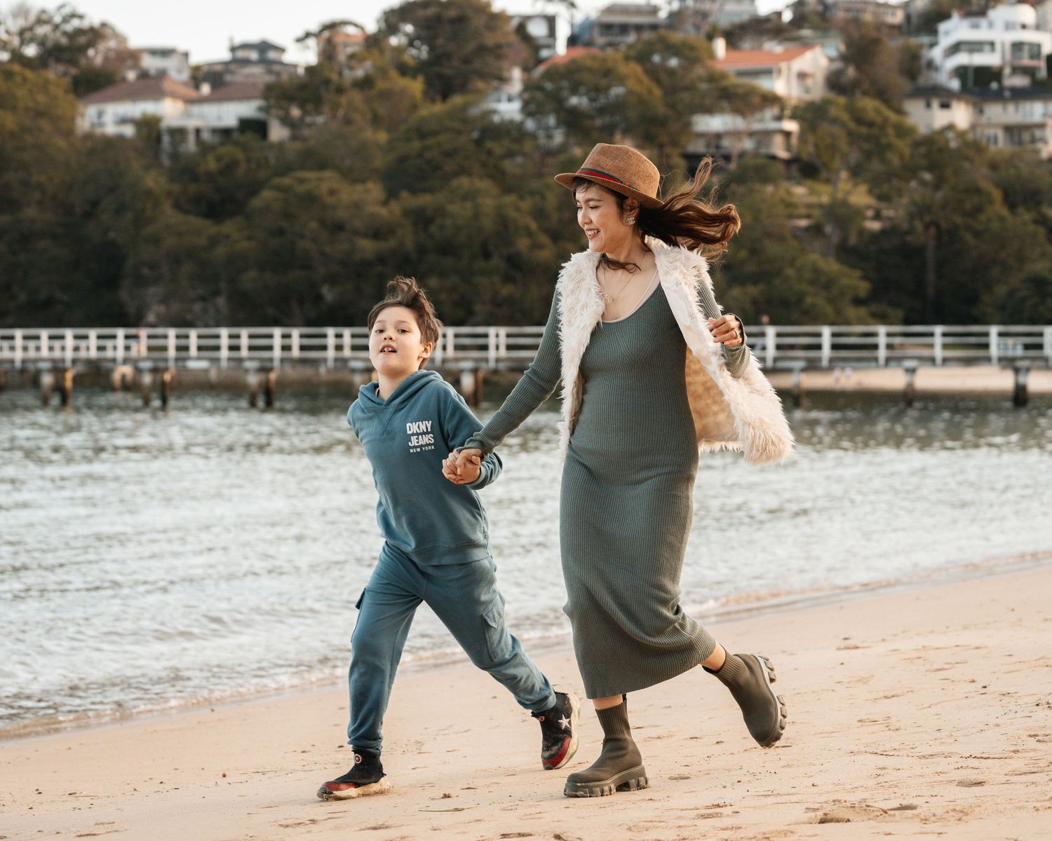 A joyful moment between a mother and son as they share a laugh during a family photoshoot in a beach at Mosman, Sydney