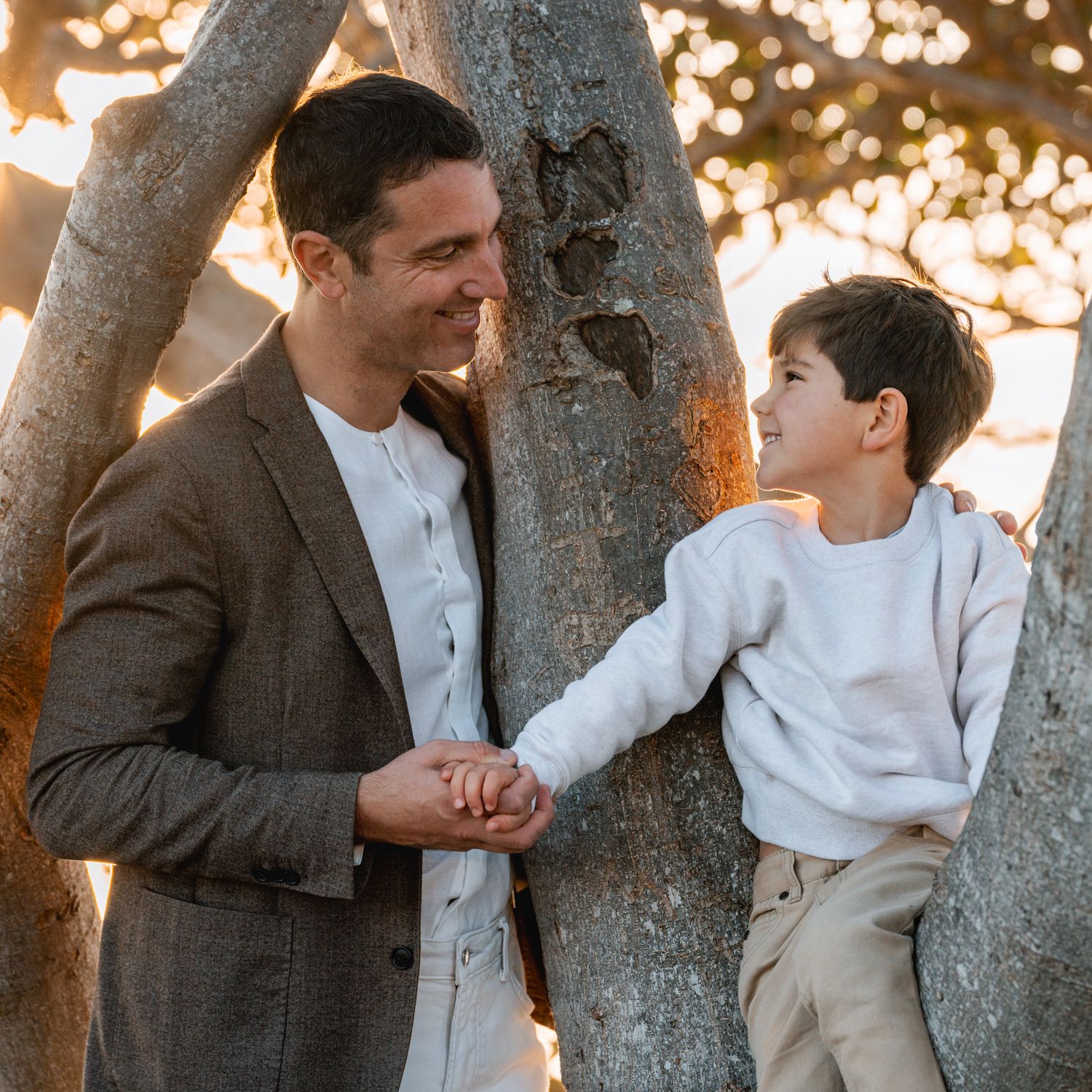 Dad and son sharing a moment while looking at each other during a sunrise family photoshoot at Balmoral Beach, Sydney