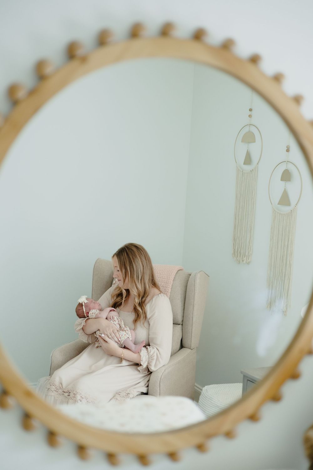 A series of mirror reflections show a person in a pink dress reclining on a white chair against a pale blue wall.