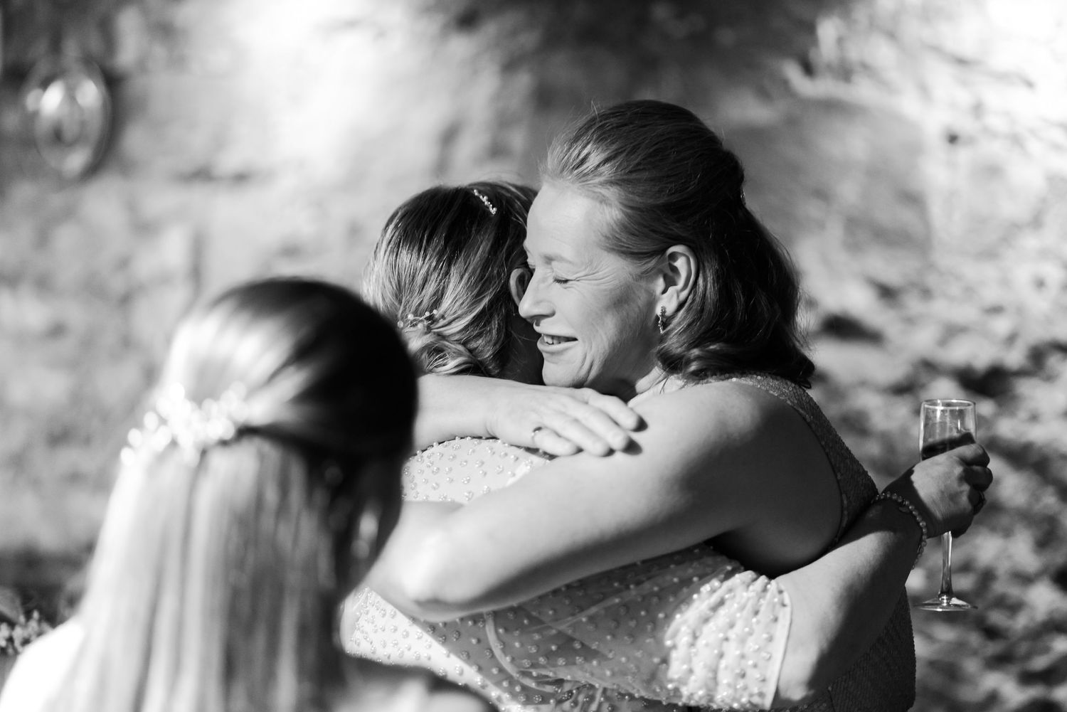 Emotional moment between friends hugging and laughing at a celebration.