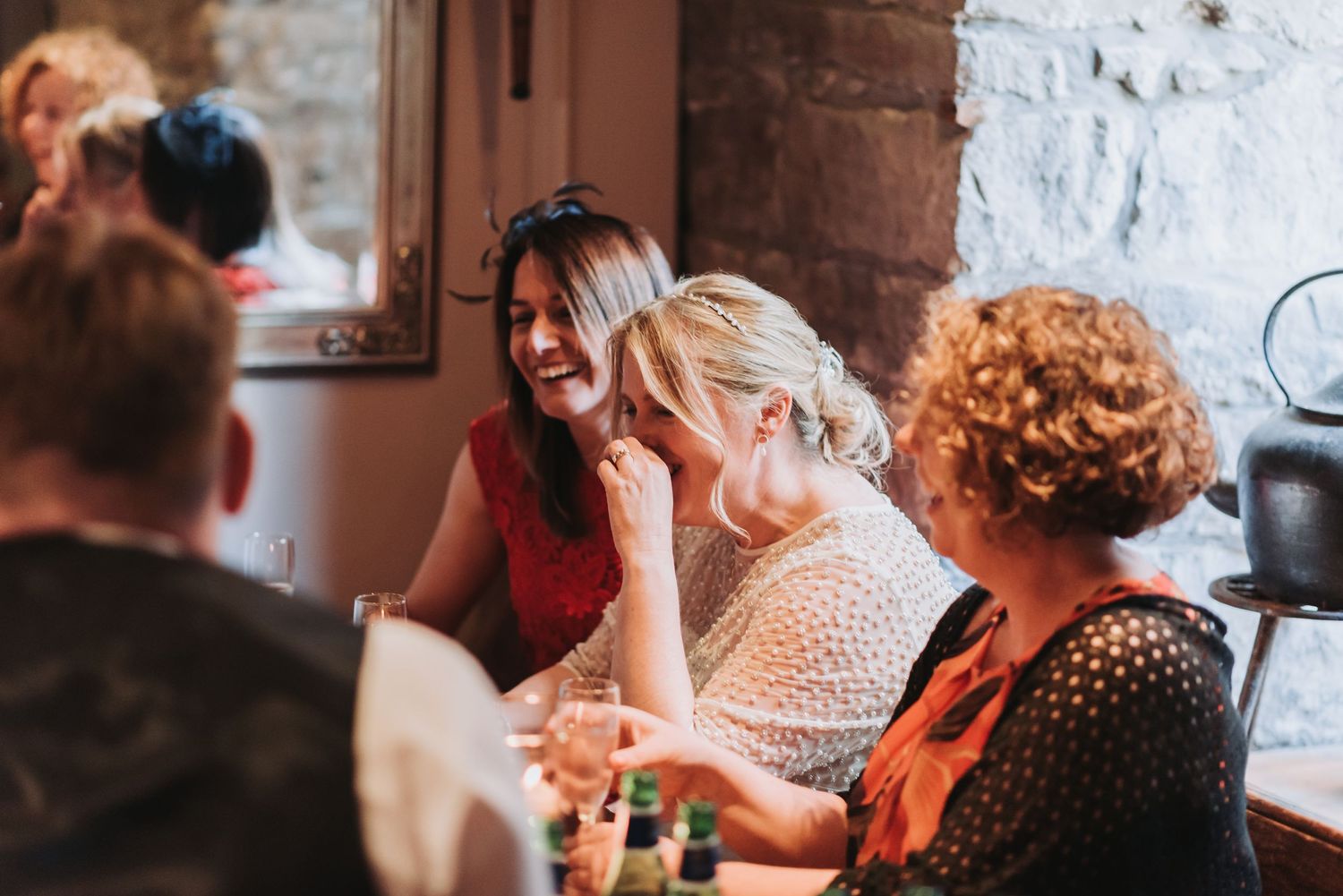 Friends sharing laughs and stories around a table at a social gathering.