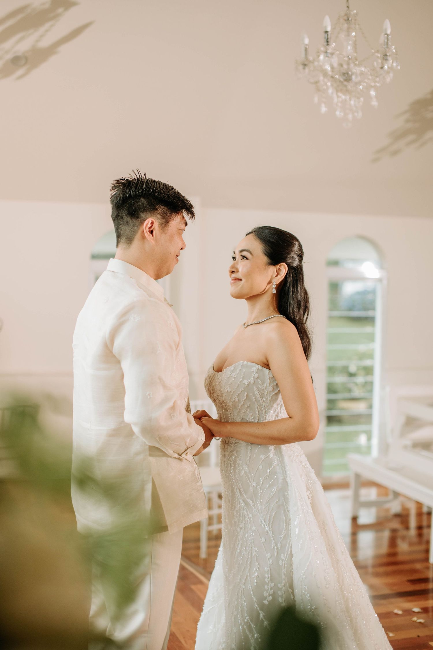 Indoor chapel wedding portrait with chandelier and natural lighting.