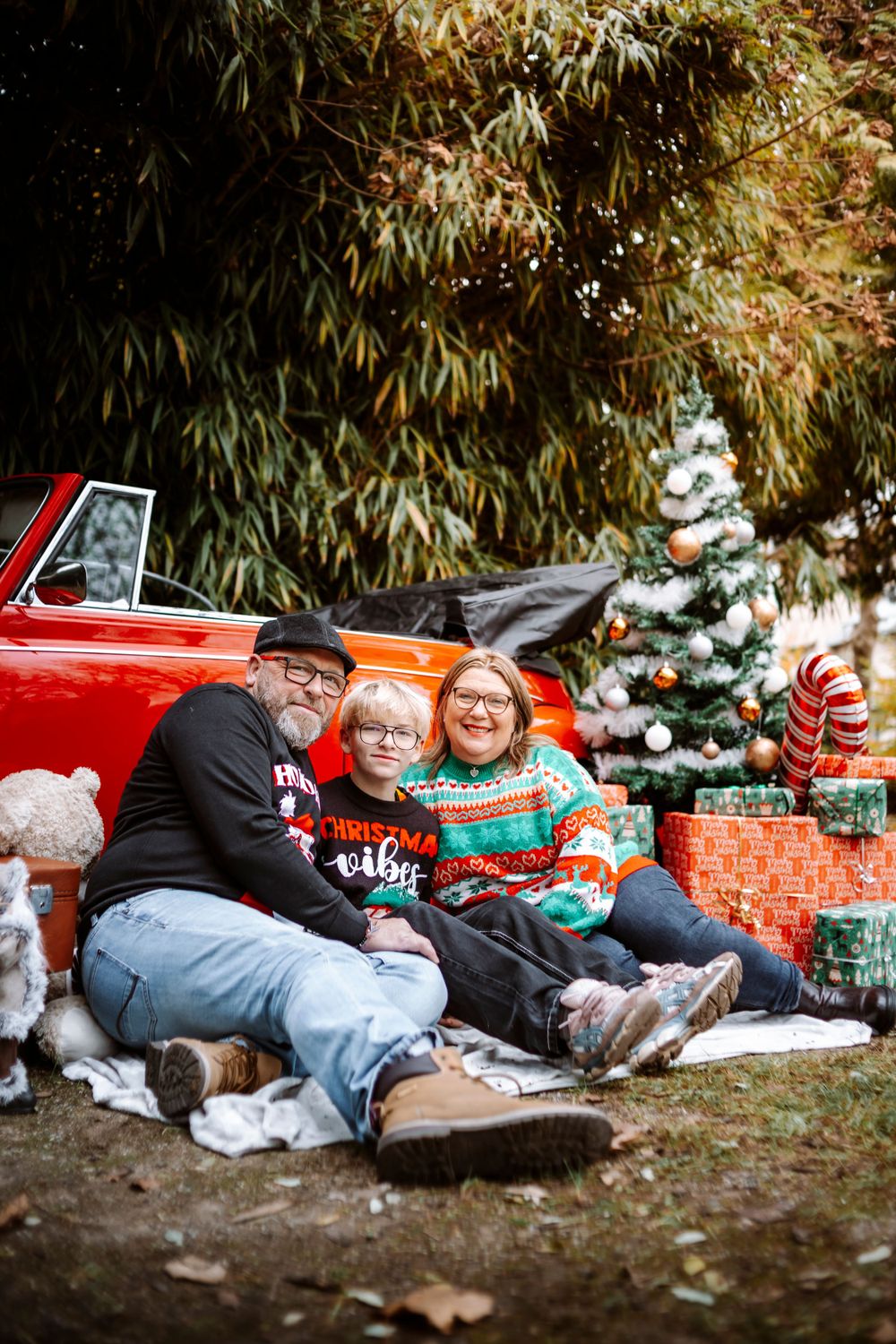 Mini-session photo de Noël 2024 avec une coccinelle VW rouge décorée pour les fêtes, créant une ambiance festive et chaleureuse.