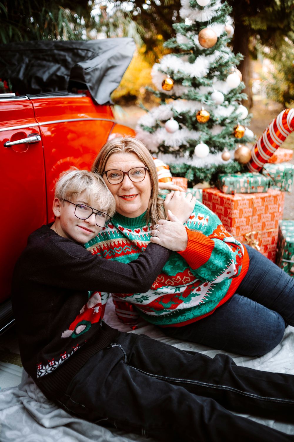 Mini-session photo de Noël 2024 avec une coccinelle VW rouge décorée pour les fêtes, créant une ambiance festive et chaleureuse.