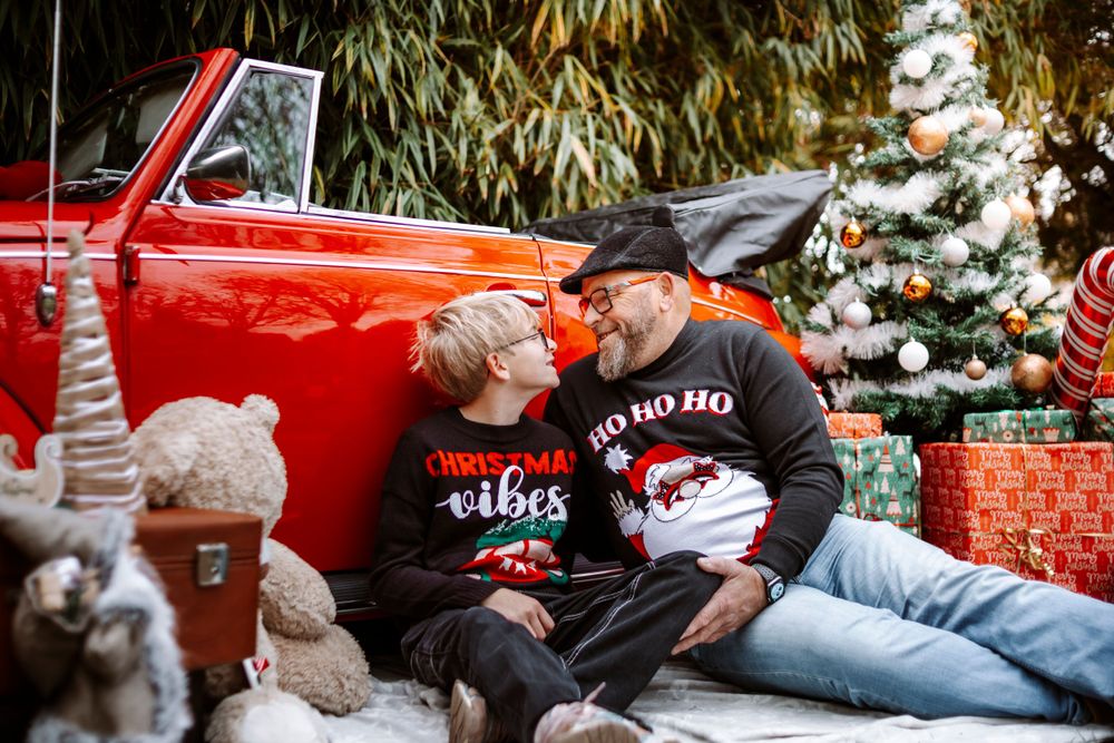 Mini-session photo de Noël 2024 avec une coccinelle VW rouge décorée pour les fêtes, créant une ambiance festive et chaleureuse.