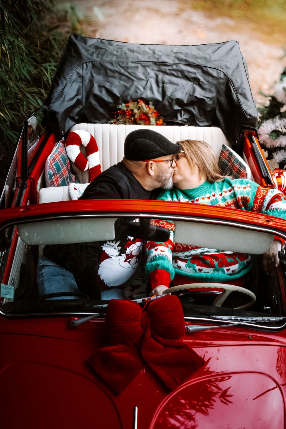 Mini-session photo de Noël 2024 avec une coccinelle VW rouge décorée pour les fêtes, créant une ambiance festive et chaleureuse.