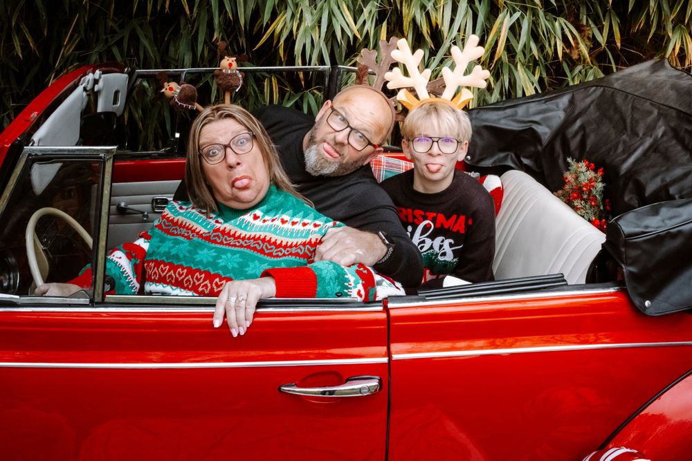 Mini-session photo de Noël 2024 avec une coccinelle VW rouge décorée pour les fêtes, créant une ambiance festive et chaleureuse.