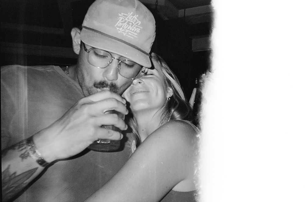 Intimate black and white photo of couple sharing drinks together.