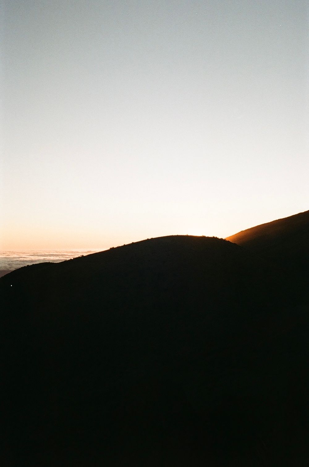 Silhouette of mountain ridge against sunset sky creating dramatic contrast and peaceful mood.