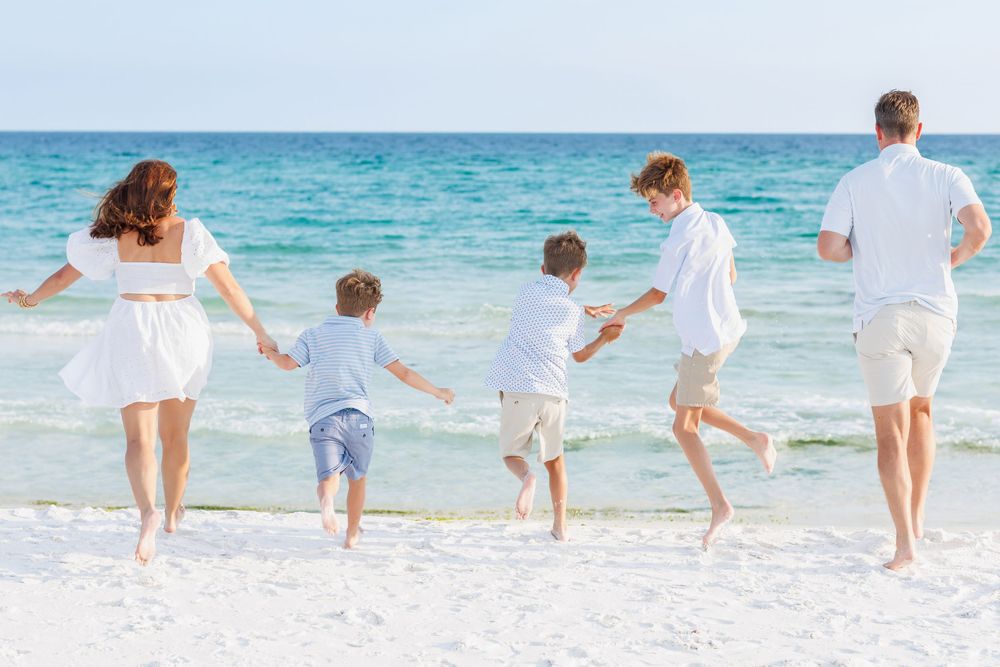 Family running toward the Gulf during a beach session in Santa Rosa Beach, on 30A in Florida