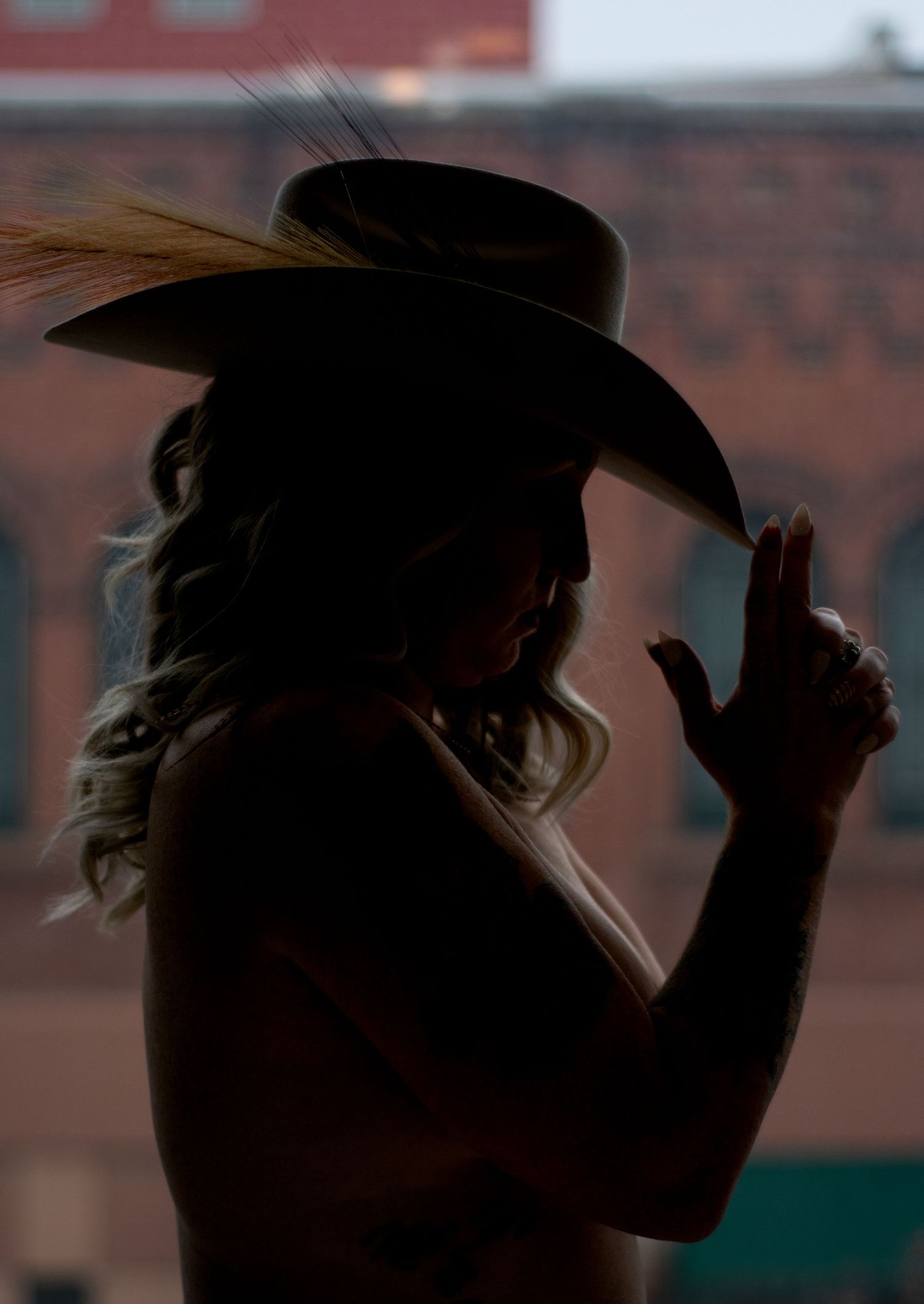 Boudoir silhouette of a woman wearing a cowboy hat.
