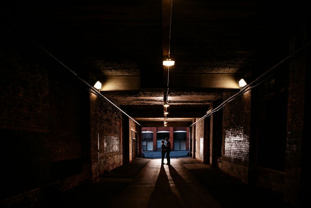 Dark underground parking garage with dramatic lighting and long corridor perspective creates moody atmosphere.