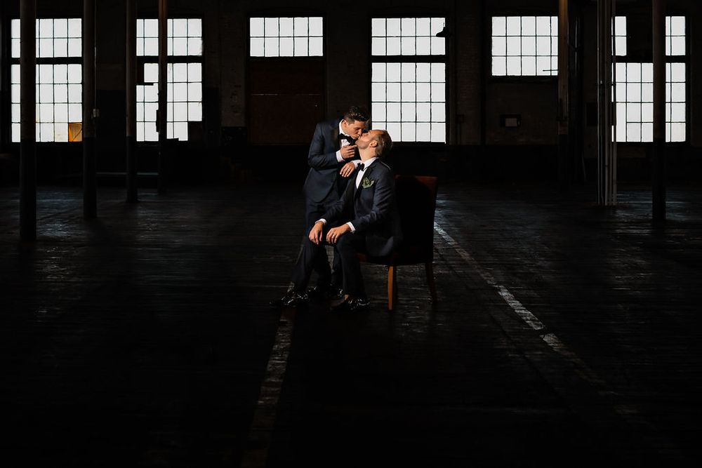 Industrial windows create dramatic lighting in dark warehouse setting.