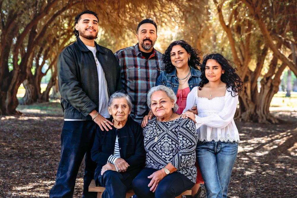 Grandmother surrounded by her children and grandchildren during a multi-generational family session in Fresno by Colibrí Captures.
