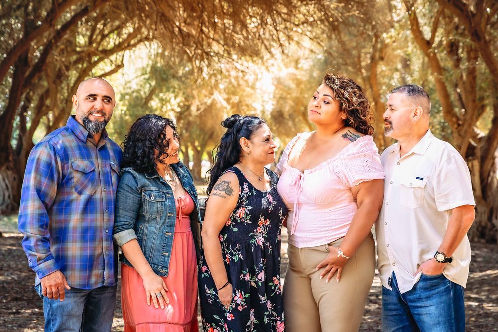 Candid sibling moment of brothers and sisters embracing during a golden-hour family photoshoot in Clovis, California.