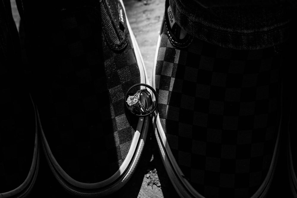 Couple in wedding attire sharing an intimate moment in black and white photography.