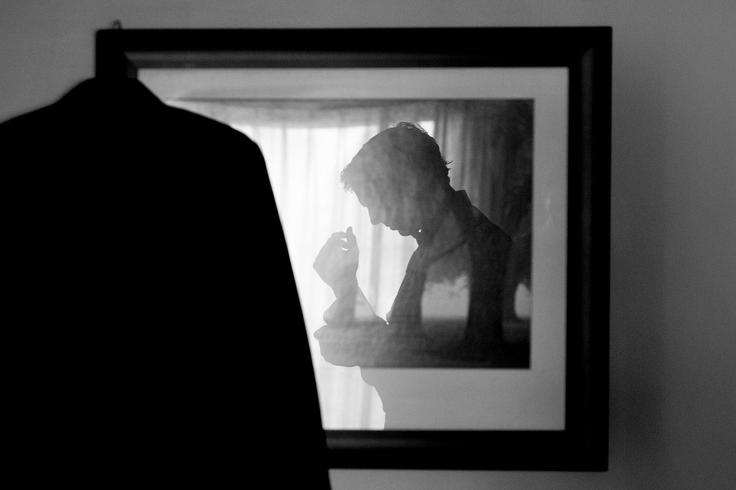 Artistic black and white composition showing silhouettes and framed photographs.