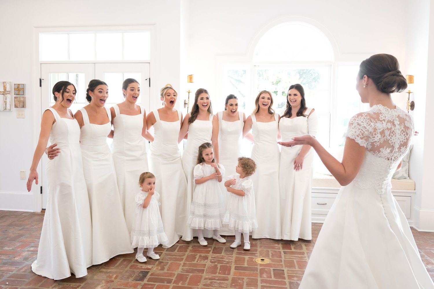 Wedding party scene with bridesmaids and flower girls in white dresses.