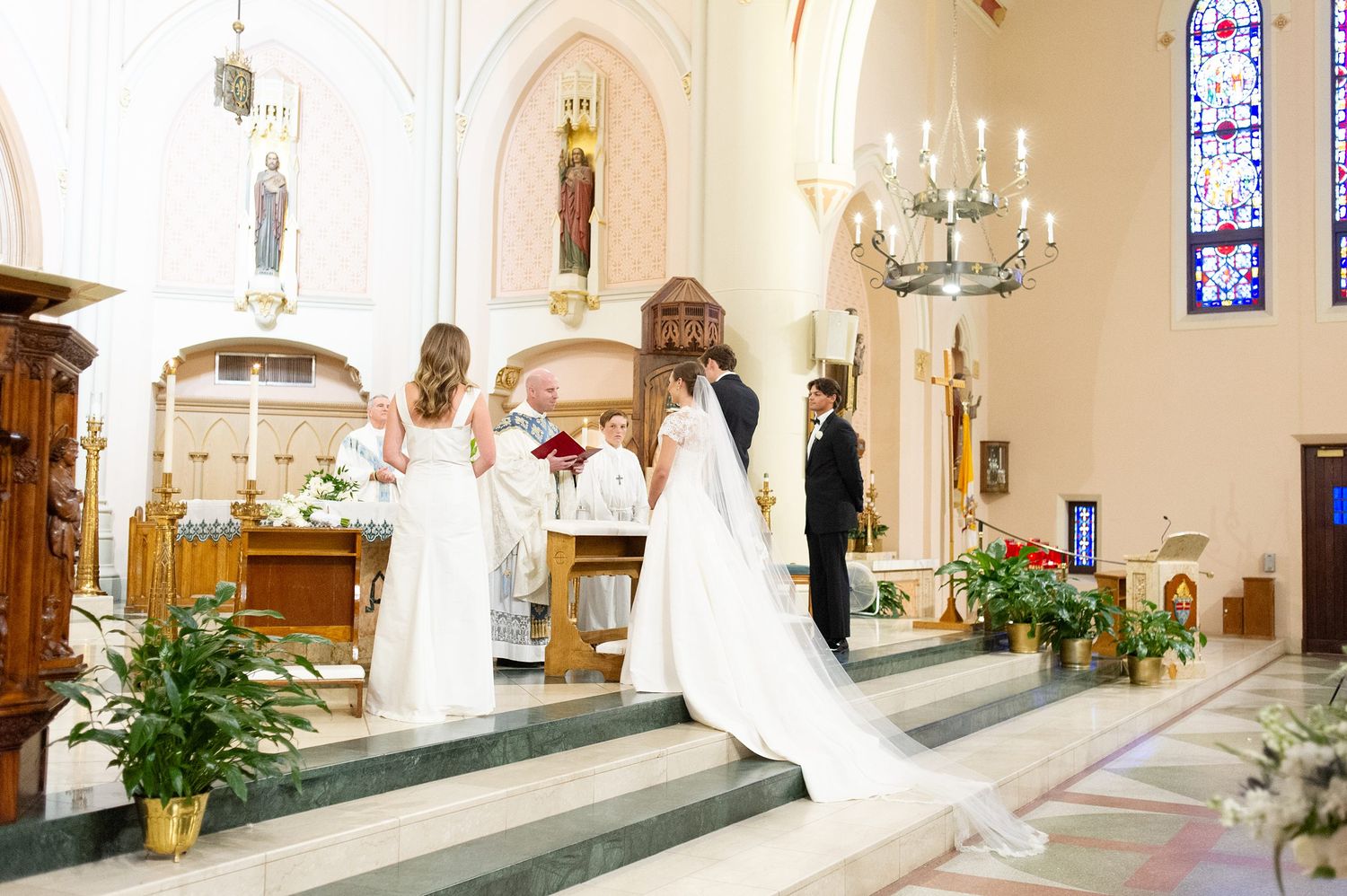 Church altar decorated with candles and stained glass windows for wedding ceremony.