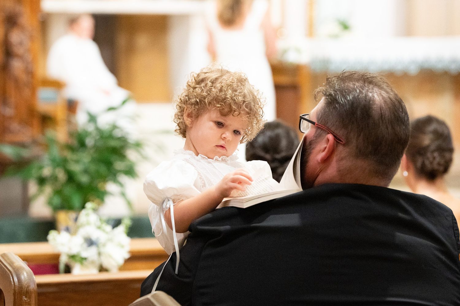 Candid moments captured during wedding ceremony in warm-lit church interior.