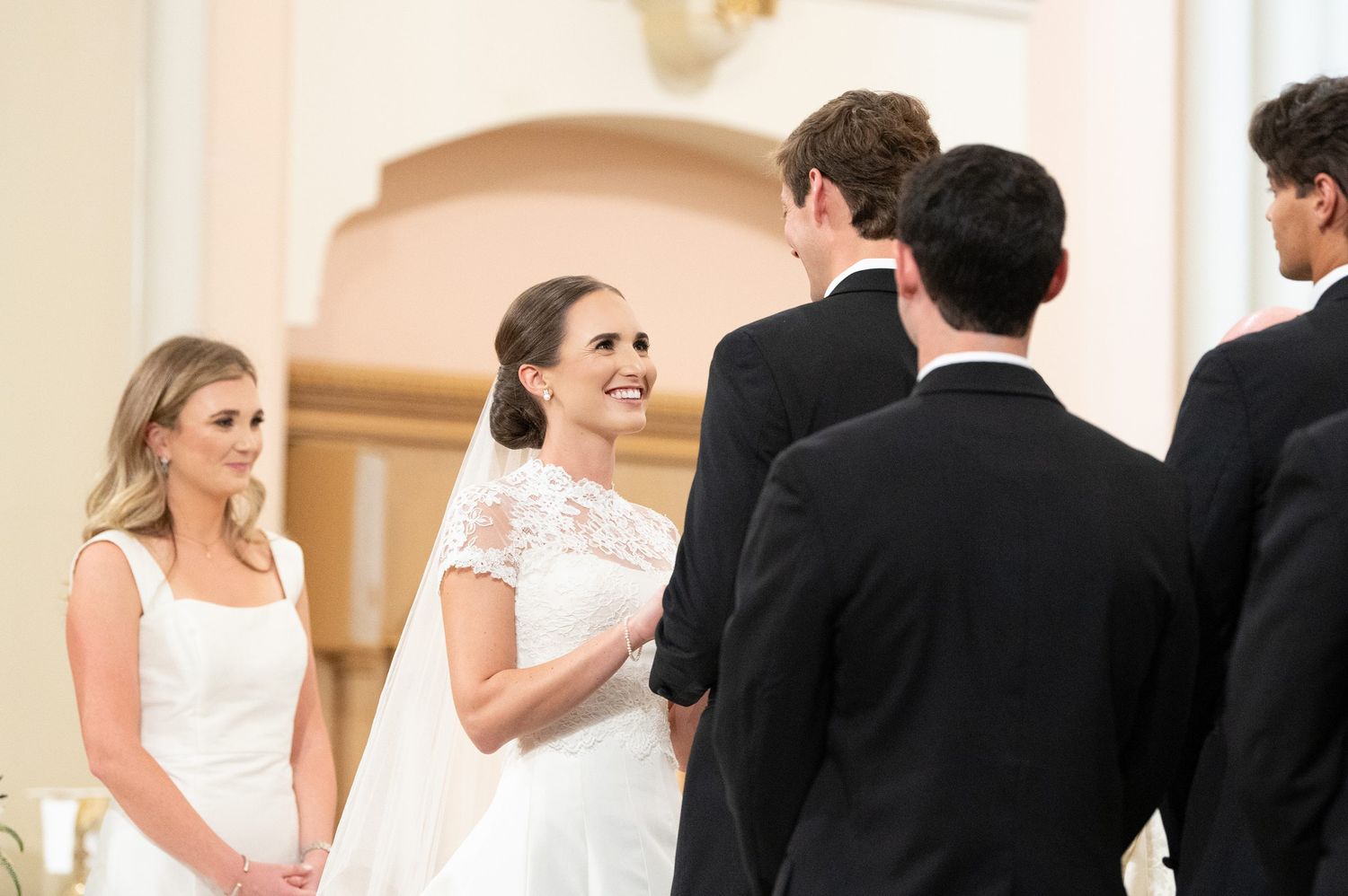 Candid moments between wedding party members in elegant church interior.