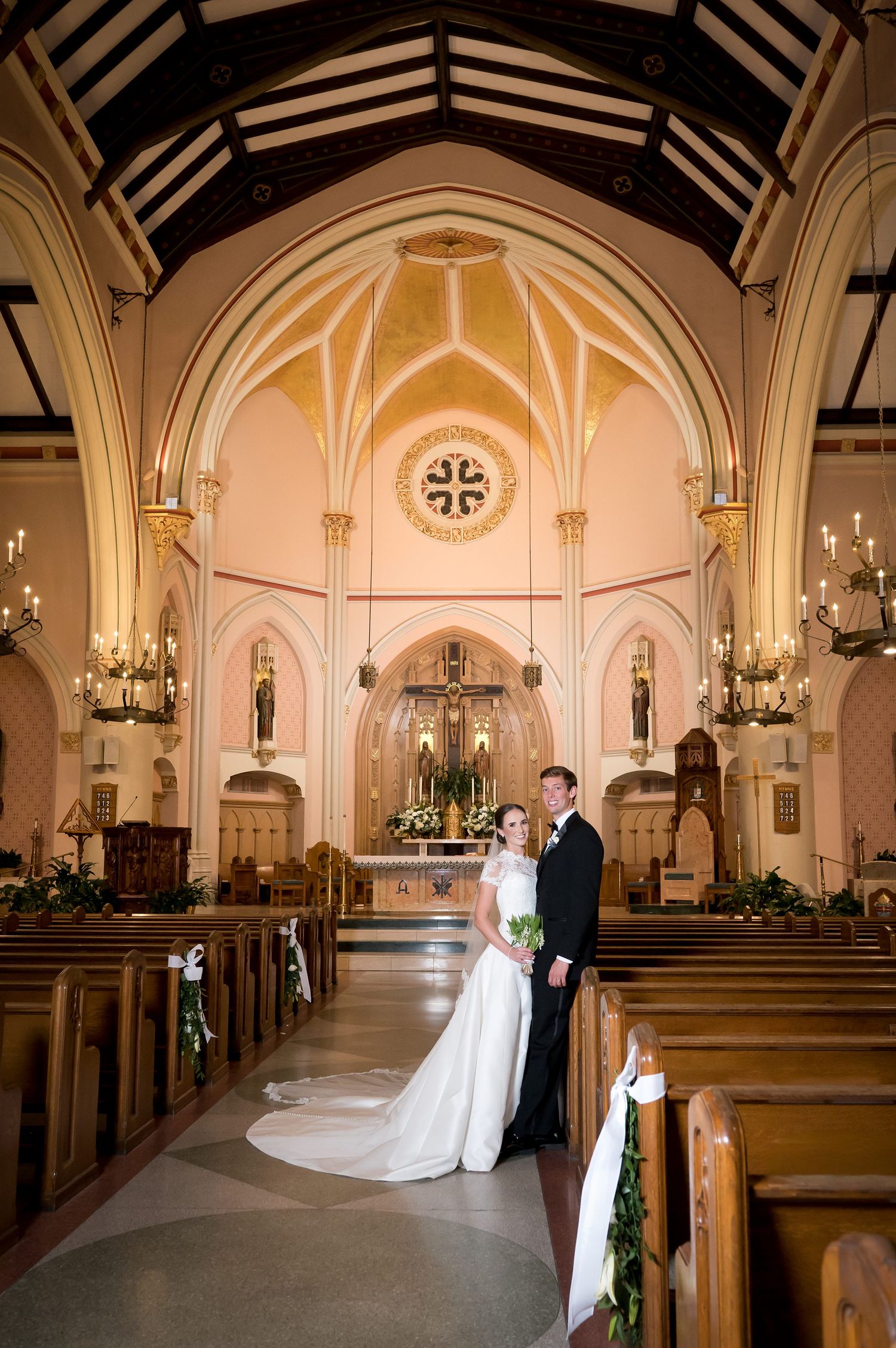 Series of romantic wedding portraits captured in a beautiful church with cream-colored walls and wooden pews.