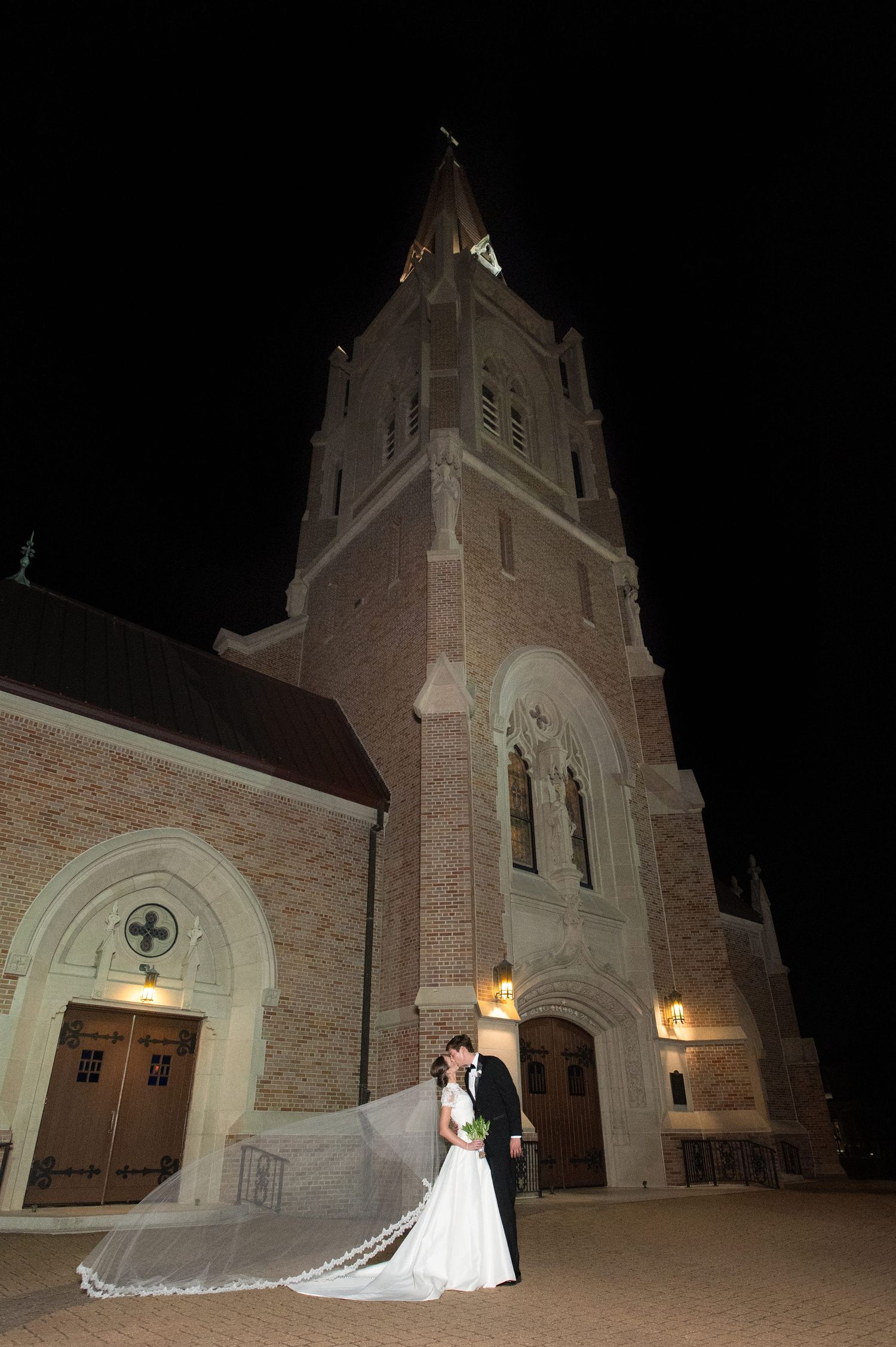 Elegant church exterior at night with illuminated archways and architectural details.